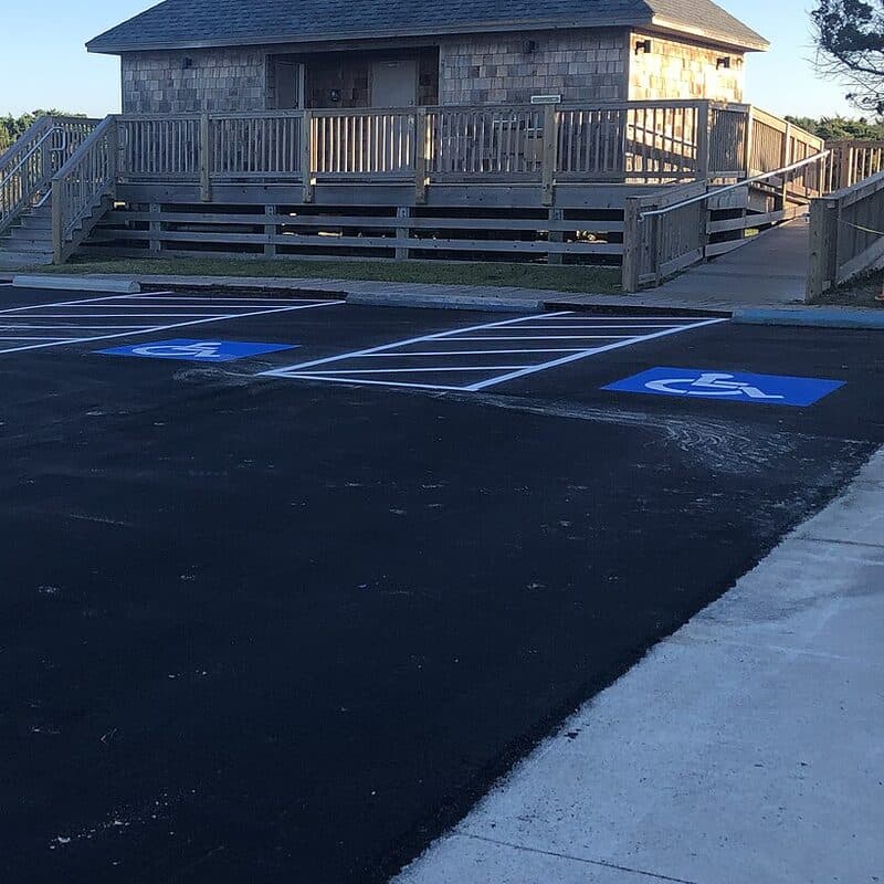 Two freshly painted accessible parking stalls with a striped access aisle between them