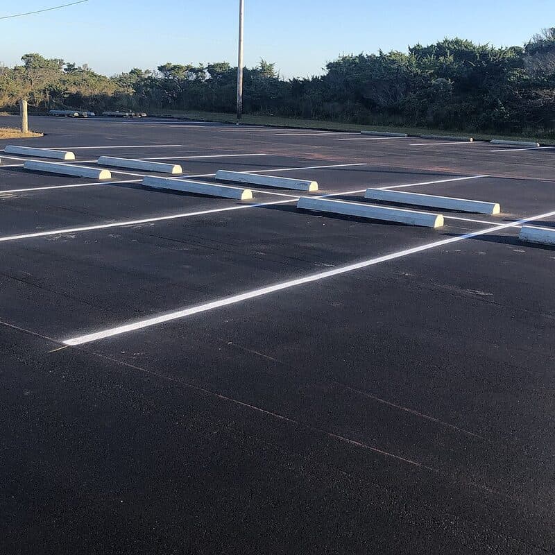 Fresh white stall lines painted on new black asphalt