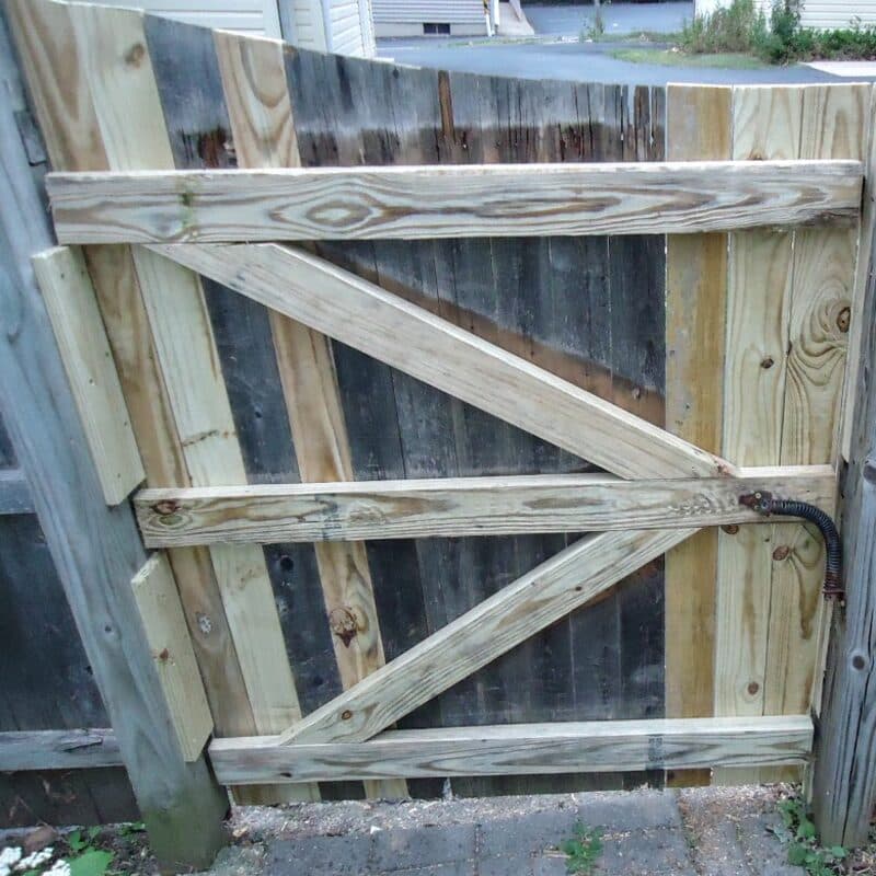 A rebuilt wood gate with new diagonal braces