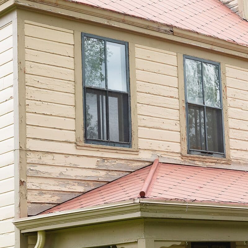 Old peeling paint on wood siding before the job