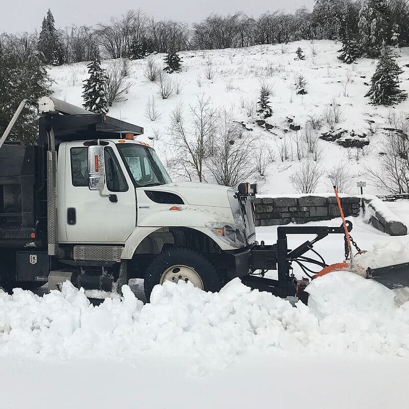 Plow truck clearing a parking lot after a snowfall
